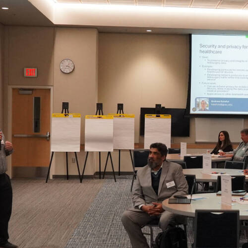 A research mixer where a faculty is presenting snapshots of his current research